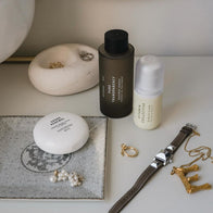 Load image into Gallery viewer, An aesthetic lifestyle flat lay of Full Ritual Set essentials on a white vanity. The image features Sound Renewal Serum Cream, Pure Transparency Treatment Essence, and Vitamin Collective Vitality Elixir styled alongside gold and pearl jewelry, a watch, and minimalist ceramic trays.