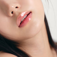 Load image into Gallery viewer, A close-up shot of a model's lips showcasing the glossy finish of the Infinite Layers Lip Care from the Modern Traveler kit. The clear, hydrating formula provides a smooth and healthy shine to the lips.