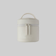 Load image into Gallery viewer, A front view of the Superegg Little Egg Vanity Bag in Eggshell cream, showing its pebbled vegan leather texture, top handle, and the debossed SUPEREGG NYC logo on the center against a light gray background.