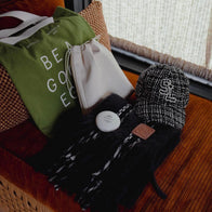 Load image into Gallery viewer, A top-down lifestyle shot featuring the Minimal Egg Cream Pouch alongside the Be a Good Egg Tote and a This Moment Hand Care. The arrangement highlights the pouch as a versatile accessory within a collection of minimalist, vegan lifestyle essentials.