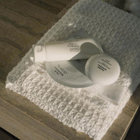 Load image into Gallery viewer, A clean, lifestyle shot of the Balanced Skin Set products—the Gentle Elements Cleansing Foam, Sound Renewal Serum Cream, and Calm Movements Eye &amp; Cheek Mask—resting on a textured white bathroom towel, highlighting a serene and organized daily skincare ritual.