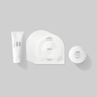 Load image into Gallery viewer, A flat lay of the Balanced Skin Set, a wellness trio for a streamlined routine. The set includes the Gentle Elements Cleansing Foam, a pack of five Calm Movements Eye &amp; Cheek Masks, and the Sound Renewal Serum Cream.