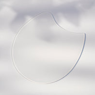 Load image into Gallery viewer, A high-detail close-up of a single Calm Movements Eye &amp; Cheek Mask. The clear, plump hydrogel mask is shown against a soft, light background, highlighting its unique C-shape design and smooth, cooling texture intended for intensive under-eye and cheek care.