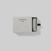 Load image into Gallery viewer, Top-down view of the Superegg Flow Egg Sculpting Gua Sha packaging, showing the open sliding gift box with "SUPEREGG NYC" printed on the fabric-textured lid and the protective pouch inside.