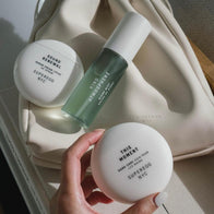 Load image into Gallery viewer, A close-up lifestyle shot of a hand holding the This Moment Hand Care against the backdrop of the Minimal Egg Cream Pouch. The Sound Renewal Serum Cream and Kind Atmosphere Biome Mist are also visible, showing how the pouch elegantly carries a full skincare and hand care routine.