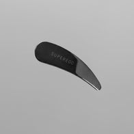 Load image into Gallery viewer, A top-down view of the Superegg silver stainless steel Precision Egg Skincare Spatula featuring an engraved logo on a minimalist light gray background.