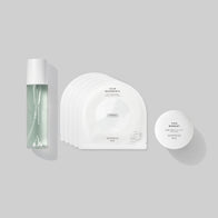 Load image into Gallery viewer, A flat lay arrangement of the Self-Care Bundle, featuring the Kind Atmosphere Biome Mist, a stack of Calm Movements Eye &amp; Cheek Masks, and the This Moment Hand Care against a neutral grey background.