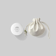 Load image into Gallery viewer, A front-facing studio shot of the Sound Renewal &amp; Lucky Egg Duru Pouch set. The spherical white "Sound Renewal" serum cream container is positioned next to the cream-colored Lucky Egg Duru Pouch with its signature green bead drawstring details.