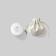 Load image into Gallery viewer, A side-by-side studio shot of the This Moment &amp; Lucky Egg Duru Pouch set. The spherical white hand cream container stands next to a cream-colored Lucky Egg Duru Pouch, a modern translation of a historical Korean drawstring pouch with green bead details.