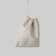Load image into Gallery viewer, A studio shot of the Minimal Egg Cream Pouch against a light grey background. This softly structured pouch is crafted from smooth cream vegan leather and features a functional drawstring top, designed to elegantly hold beauty essentials.