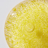 Load image into Gallery viewer, A macro close-up showing the unique texture of the Vitamin Collective Vitality Elixir. The bright yellow serum is filled with dense, white vitamin oil micro-capsules that provide a rich, concentrated treatment for the skin.